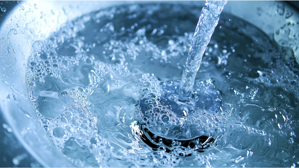 Close-up of water bubbling and draining down a clean bathroom sink.