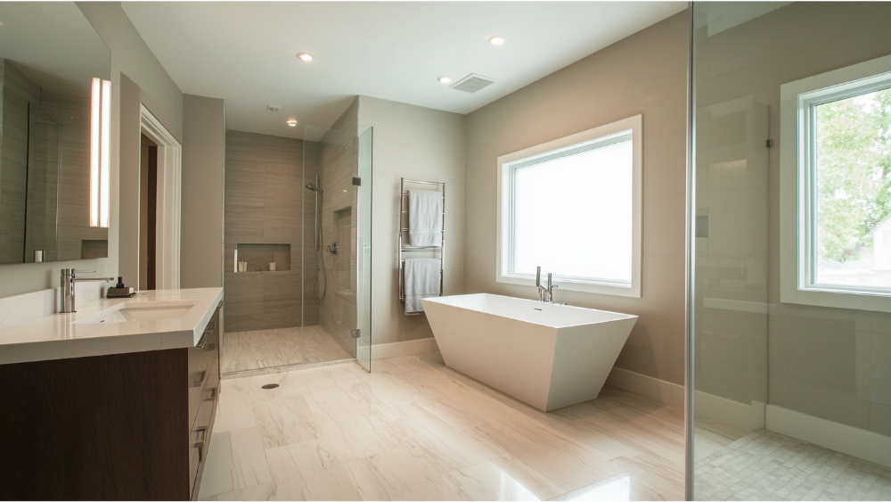 Minimalist bathroom with sleek design, featuring a walk-in shower, freestanding tub, and double vanity under soft recessed lighting.