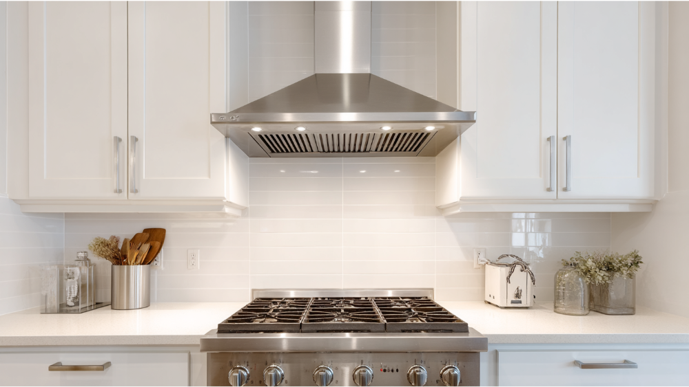 Stainless steel range and hood in a white kitchen with subway tile backsplash.