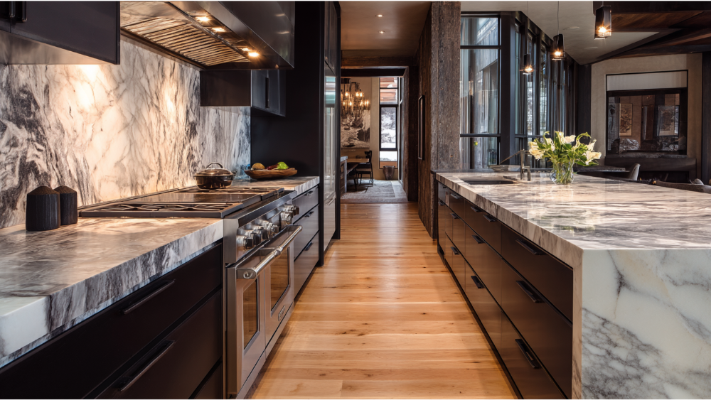 A contemporary kitchen with striking black cabinetry and white marble countertops, featuring dual islands and high-end finishes.