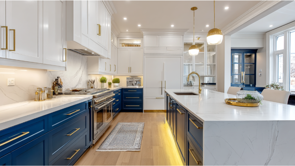 A luxury kitchen with navy blue lower cabinets, white upper cabinets, gold hardware, and a large white marble island.