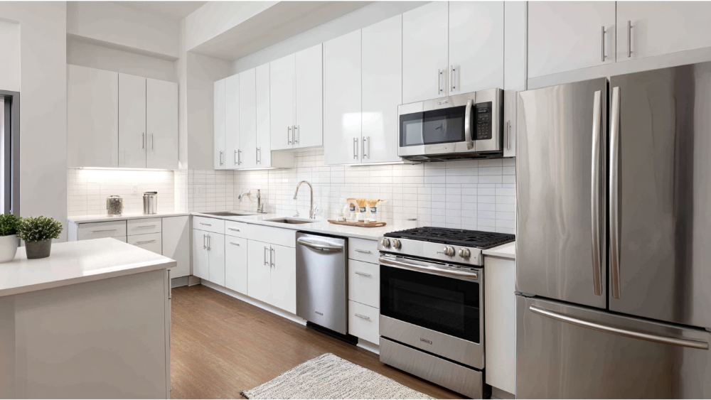 A bright kitchen with white cabinets, subway tile backsplash, stainless steel appliances, and light wood flooring.